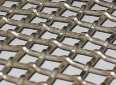A piece of lock woven vibrating screen mesh on the gray background.